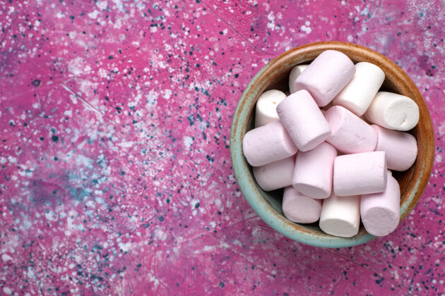 饼干顶上近距离看甜蜜美味的棉花糖在粉红色桌子上的圆锅里小形成瓷砖糖果棉花糖