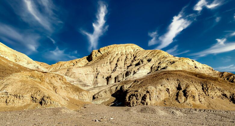 美国在多云的蓝天下 美国加利福尼亚州死亡谷一个岩层的低角度拍摄阳光日岩石形成形成