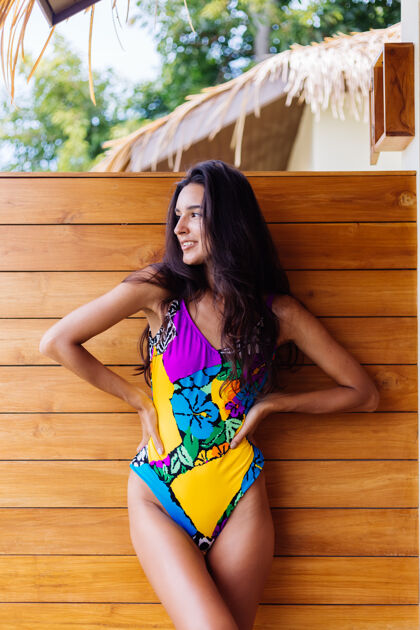女人年轻漂亮的积极快乐的苗条女子 穿着五颜六色的泳衣 在豪华的酒店别墅享受泰国度假的美好日子休闲海滩肖像