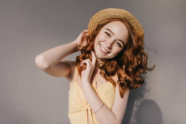 配件兴奋的高加索女孩 姜黄色头发 在灰色的墙上摆姿势美丽的白色年轻女子在优雅的夏季帽子的照片可爱帽子美丽