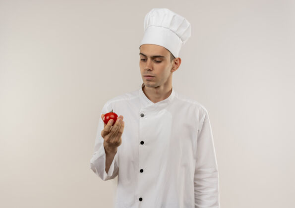 番茄想着年轻的男厨师穿着厨师制服看着手里拿着西红柿的复印空间厨师穿制服