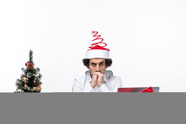 圣诞老人体贴的年轻商人戴着滑稽的圣诞老人帽 在白色背景下思考着办公室里的事情年轻商人成人年轻
