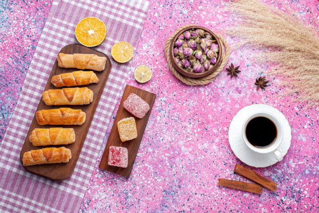 糖在粉红色的地板上 可以俯瞰一杯带有果酱片和百吉饼的茶茶糕点甜食