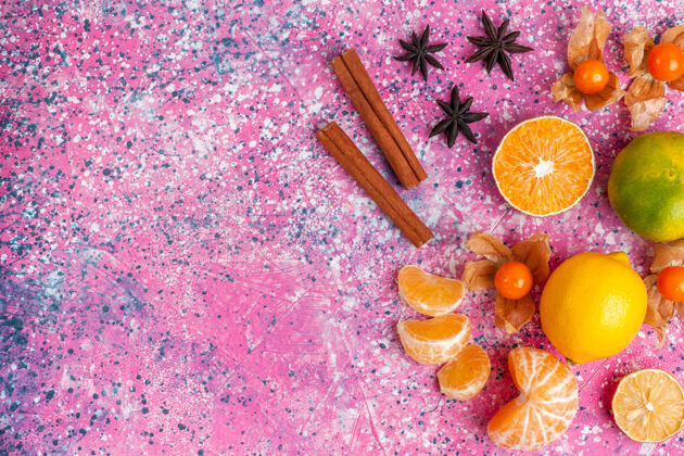 粉红色在浅粉色的背景上俯瞰新鲜的酸橘子和柠檬和肉桂柑橘花五颜六色