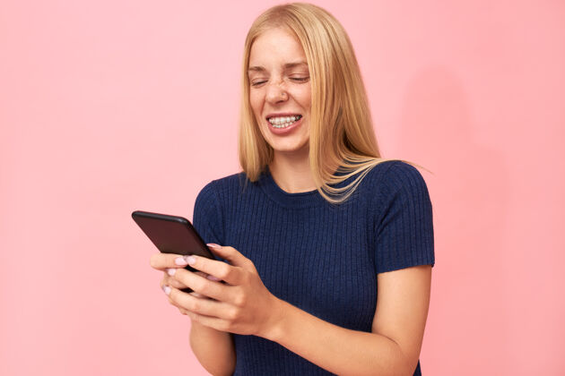 在线美丽的情感年轻的欧洲女人牙齿托槽和雀斑聊天通过手机上的应用程序与朋友在线女人学生乐趣