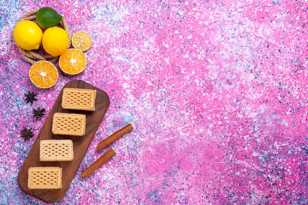 季节华夫饼三明治饼干的顶视图 带有水果奶油馅和浅粉色表面的茶装饰桌子甜点