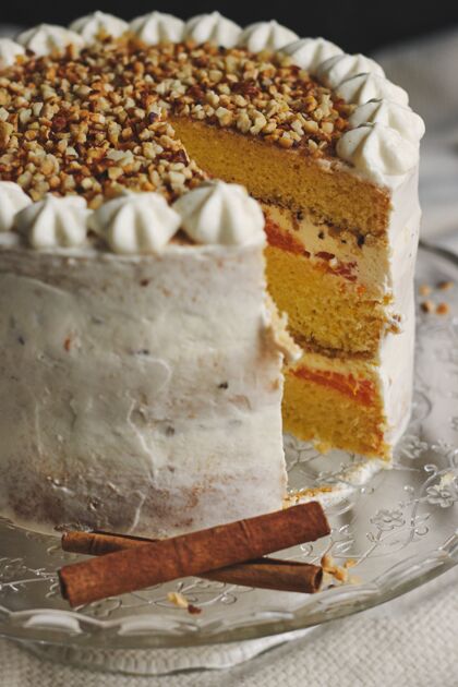 美味特写一个白色美味的圣诞切片蛋糕坚果和柑橘糖果棍子糕点