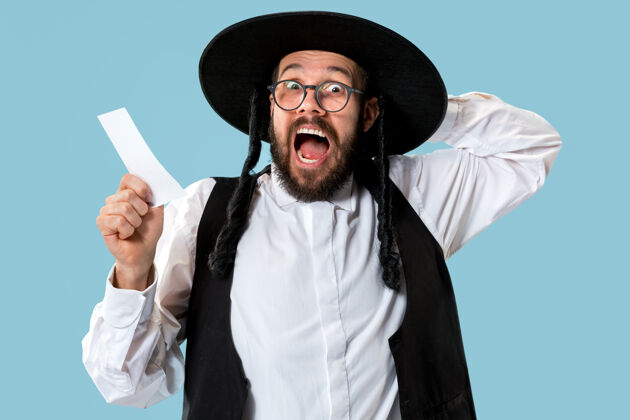 一个年轻的东正教犹太教男子的肖像与赌票在工作室男性应用程序在线
