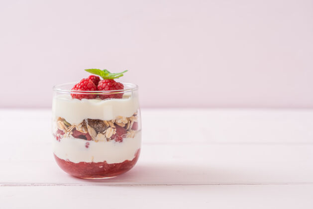 零食新鲜的覆盆子和酸奶与格兰诺拉麦片-健康的食物风格种子草莓早晨