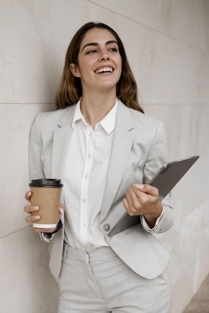 个人微笑优雅的女商人手持平板电脑和咖啡杯精致女商人行政人员