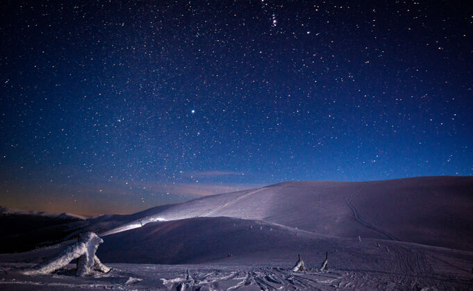 梦在迷人的星空映衬下 可以看到神奇的山峦 雪山和滑雪坡冬季自然和户外休闲的概念月光山银河