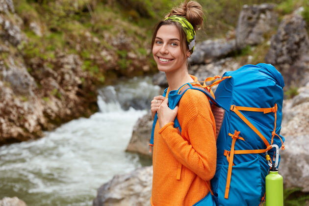 风景积极的休息和积极的情绪概念欢快的女性穿着休闲的橙色套头衫 背着旅游背包刷新自然秋天