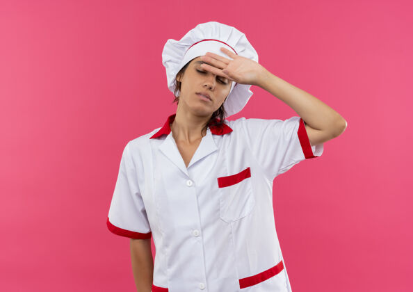 女闭上眼睛疲惫的年轻女厨师穿着厨师制服 把手放在额头上 留着空间疲倦厨师制服