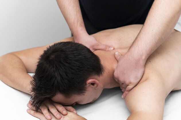 物理理疗师给男病人做背部按摩治疗学物理治疗男人