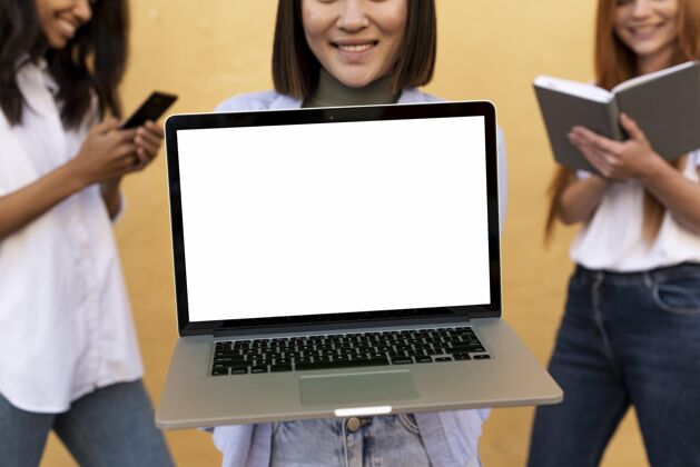 漂亮亚洲女人展示一台空白笔记本电脑漂亮成人笔记本电脑