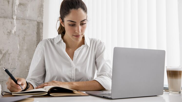 精致女商人使用笔记本电脑和笔记本电脑的前视图专业人士高管企业家