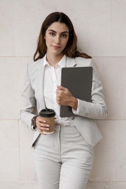 优雅手持平板电脑和咖啡杯的女商人正面图咖啡精致个人