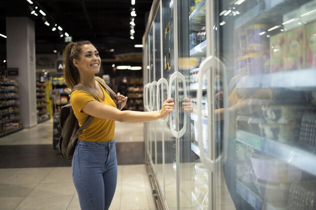 杂货店女人用购物车打开冰箱去杂货店拿食物有机人消费者