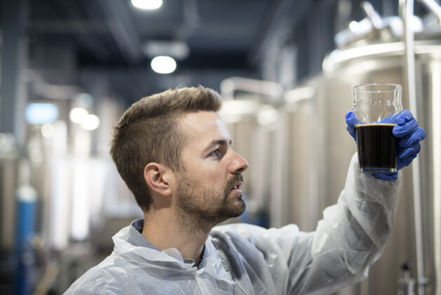 质量啤酒厂的技术员在检查啤酒质量业务手工制作现代