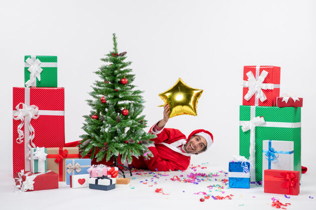 不同圣诞气氛与圣诞老人躺在圣诞树旁的礼物在不同颜色的白色背景下圣诞圣诞树礼物