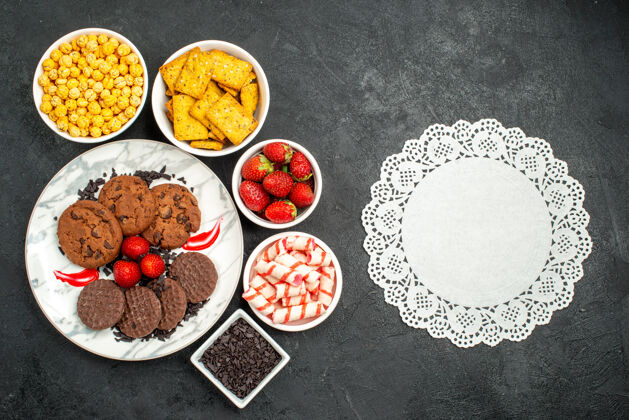 晚餐顶视图美味巧克力饼干与不同的零食在黑暗背景饼干甜茶茶美味水果