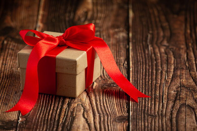 庆祝木制背景上有红丝带蝴蝶结的礼物盒盒子现代盒子
