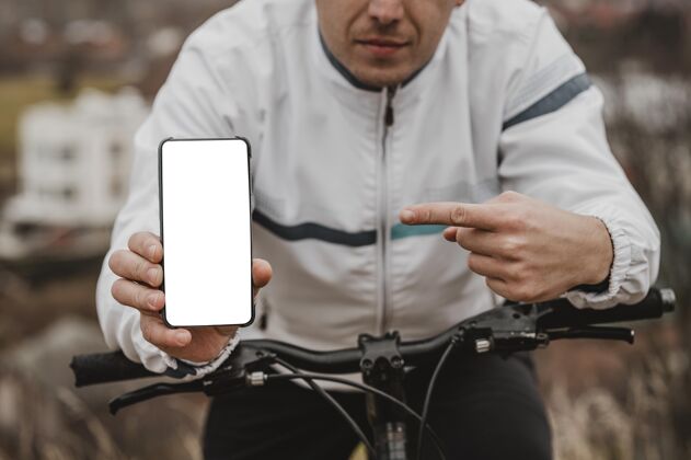 骑自行车男人指着他的空白电话爱好运动自行车