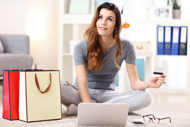 女性美女用信用卡在线购物休闲女孩电脑