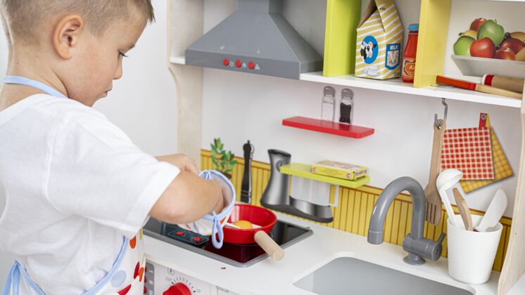 性别可爱的孩子在玩烹饪游戏正常玩具身份