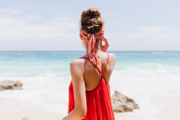 沙滩浪漫少女在沙滩上休息时穿着红色服装的照片极乐少女享受海景的户外照片天堂山休闲